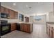 Bright kitchen features wooden cabinetry, black appliances, and tile flooring at 10287 S 175Th Ave, Goodyear, AZ 85338
