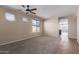 Spacious living room featuring carpeted floors, a ceiling fan, and multiple windows at 10287 S 175Th Ave, Goodyear, AZ 85338