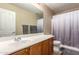 Bathroom featuring a double sink vanity with wood cabinets, a mirror, and a shower with curtain at 11872 W Sherman St, Avondale, AZ 85323