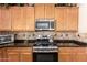 Kitchen with granite countertops, stainless steel appliances, and light wood cabinets at 11872 W Sherman St, Avondale, AZ 85323