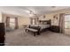 Spacious main bedroom with plush carpet, ceiling fan, curtains, and an ensuite bath at 11872 W Sherman St, Avondale, AZ 85323