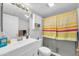 Bright bathroom with new vanity, fixtures, and shower with yellow-stripped curtain at 12123 W Bell Rd # 359, Surprise, AZ 85378