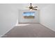 Bright, carpeted bedroom featuring a ceiling fan and a large window offering natural light at 1227 E Indigo St, Gilbert, AZ 85298