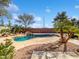 Beautiful backyard pool with rock waterfall feature, surrounded by desert landscaping at 1227 E Indigo St, Gilbert, AZ 85298