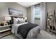 Comfortable bedroom featuring a queen size bed, decorative pillows, and a bright window view at 12556 W Trumbull Rd, Avondale, AZ 85323