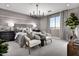Spacious main bedroom featuring a king bed, decorative light fixture, and ample natural light at 12556 W Trumbull Rd, Avondale, AZ 85323