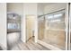 Bathroom featuring wood-look floors and a tiled walk-in shower with glass door at 15412 N 160Th Ln, Surprise, AZ 85374