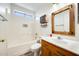 Bathroom features a shower over tub, wood frame mirror and updated lighting fixtures above the vanity at 15412 N 160Th Ln, Surprise, AZ 85374
