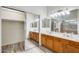 Bathroom with double sink vanity, mirrored sliding closet doors, and decorative lighting at 15412 N 160Th Ln, Surprise, AZ 85374