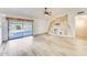 Spacious living room featuring laminate flooring, a ceiling fan, and large sliding doors leading to a backyard pool at 15412 N 160Th Ln, Surprise, AZ 85374