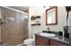 Updated bathroom features a glass shower, wood-look floors, rustic shelves, and a modern sink at 1633 W Andorra Dr, Phoenix, AZ 85029