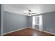Comfortable bedroom with wood-look floors, a ceiling fan, and a large window for natural light at 1633 W Andorra Dr, Phoenix, AZ 85029