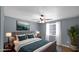 Nicely staged bedroom featuring hardwood floors, a ceiling fan, and a large window for natural light at 1633 W Andorra Dr, Phoenix, AZ 85029