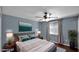 Cozy bedroom with ceiling fan, wood-look floors, large window, neutral walls, and soft decor at 1633 W Andorra Dr, Phoenix, AZ 85029
