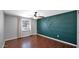 This bedroom boasts hardwood floors, a ceiling fan, and a textured accent wall at 1633 W Andorra Dr, Phoenix, AZ 85029
