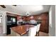 Updated kitchen with dark wood cabinets, mosaic backsplash, island, and black appliances provides a luxurious cooking space at 1633 W Andorra Dr, Phoenix, AZ 85029