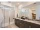 Modern bathroom featuring double sinks, granite countertops, and a glass enclosed shower with marble-look surround at 16694 W Audrey Ln, Surprise, AZ 85387