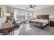 Spacious carpeted bedroom with large windows, ceiling fan, desk, and wooden bed frame at 1785 S Morrison Ln, Gilbert, AZ 85295