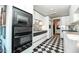 Well lit galley kitchen with black and white checkerboard flooring and modern black appliances at 2323 N Central Ave # Ph-C, Phoenix, AZ 85004