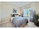 Inviting bedroom with soft blue bedding, large window, and decorative plant, creating a relaxing retreat at 24973 N 174Th Ave, Surprise, AZ 85387