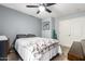 Bedroom with gray walls, a ceiling fan, and a white bed with a patterned comforter at 25844 W Watkins St, Buckeye, AZ 85326