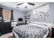 Bedroom with gray walls, a ceiling fan, and a white bed with a geometric patterned comforter at 25844 W Watkins St, Buckeye, AZ 85326