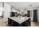 Bright kitchen features granite counters, white cabinets, modern black appliances, and an island with bar seating at 25844 W Watkins St, Buckeye, AZ 85326