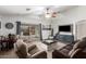 Cozy living room featuring a ceiling fan, plush seating, and sliding glass doors to the backyard at 25844 W Watkins St, Buckeye, AZ 85326