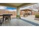 Covered patio featuring a grill and tiled flooring that leads to a backyard pergola with a dining set at 25844 W Watkins St, Buckeye, AZ 85326