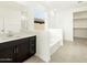 Bright bathroom featuring a soaking tub, dark vanity, and walk-in closet at 2639 E Santa Ynez Dr, Casa Grande, AZ 85194