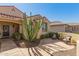 Inviting front porch with patio seating surrounded by desert landscaping and well-maintained shrubs at 26983 W Runion Dr, Buckeye, AZ 85396