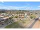 Wide aerial view of a suburban community with manicured landscaping, nearby golf course, and clear blue skies at 29081 N Cactus Cir, San Tan Valley, AZ 85143