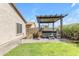 This backyard features a hot tub under a pergola next to a built-in outdoor kitchen at 29081 N Cactus Cir, San Tan Valley, AZ 85143