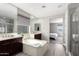 Serene bathroom showcasing a soaking tub, dual sinks, neutral color scheme, and a view of the Primary bedroom at 2926 W Thorn Tree Dr, Phoenix, AZ 85085