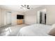 Bedroom with a ceiling fan, light wood dresser, and view of the ensuite bathroom with glass shower at 2926 W Thorn Tree Dr, Phoenix, AZ 85085
