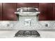 Close-up of a modern gas cooktop with stainless steel appliances and a stylish backsplash at 2926 W Thorn Tree Dr, Phoenix, AZ 85085