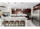 Stylish kitchen with an island, pendant lighting, stainless steel appliances, and dark wood cabinetry at 2926 W Thorn Tree Dr, Phoenix, AZ 85085