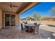 Covered patio area with tile flooring, ceiling fan, and outdoor dining set at 2926 W Thorn Tree Dr, Phoenix, AZ 85085