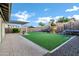 This backyard has a pristine artificial grass lawn, a pergola-covered patio, and a play area with a trampoline and playset at 29374 N 125Th Dr, Peoria, AZ 85383