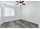 Bright bedroom features sleek wood flooring, ceiling fan and mini-blinds at 29374 N 125Th Dr, Peoria, AZ 85383