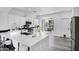 Modern kitchen with large marble island, white cabinetry, stainless appliances, and luxury flooring at 29374 N 125Th Dr, Peoria, AZ 85383