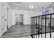 Spacious, airy loft area with gray floors, white walls, and wrought iron railing overlooking the lower level at 29374 N 125Th Dr, Peoria, AZ 85383