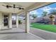 Covered outdoor patio with ceiling fans views a backyard featuring a play area and artificial turf at 29374 N 125Th Dr, Peoria, AZ 85383