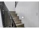 Elegant staircase featuring wooden steps, wrought iron railing, and textured wall finish with integrated lighting at 29374 N 125Th Dr, Peoria, AZ 85383