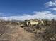 Exterior shot of a home with desert plants in the foreground and a blue sky above at 3200 S Mesa Rd, Winkelman, AZ 85192