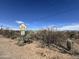 Cattle guard sign with warning and exterior shot of a home with desert plants in the background at 3200 S Mesa Rd, Winkelman, AZ 85192