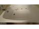 Close up of a jetted bathtub with water faucet and chrome handles at 3515 E Winchcomb Dr, Phoenix, AZ 85032