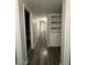 Long hallway with hardwood floors and a built-in shelf and cabinet for convenient storage at 3515 E Winchcomb Dr, Phoenix, AZ 85032
