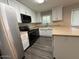 Well-lit kitchen featuring white cabinets, black appliances, and counter seating at 3515 E Winchcomb Dr, Phoenix, AZ 85032