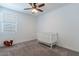 Bright bedroom with a ceiling fan, window, and crib for a Bedroom at 37051 N Rhinelander Dr, San Tan Valley, AZ 85140
